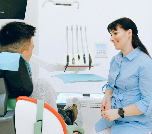 Dentist talking with a patient seated in the treatment chair