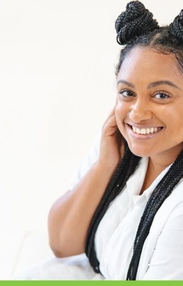 Smiling woman with braided hair buns.