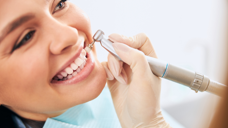 Woman receiving dental treatment, smiling brightly.