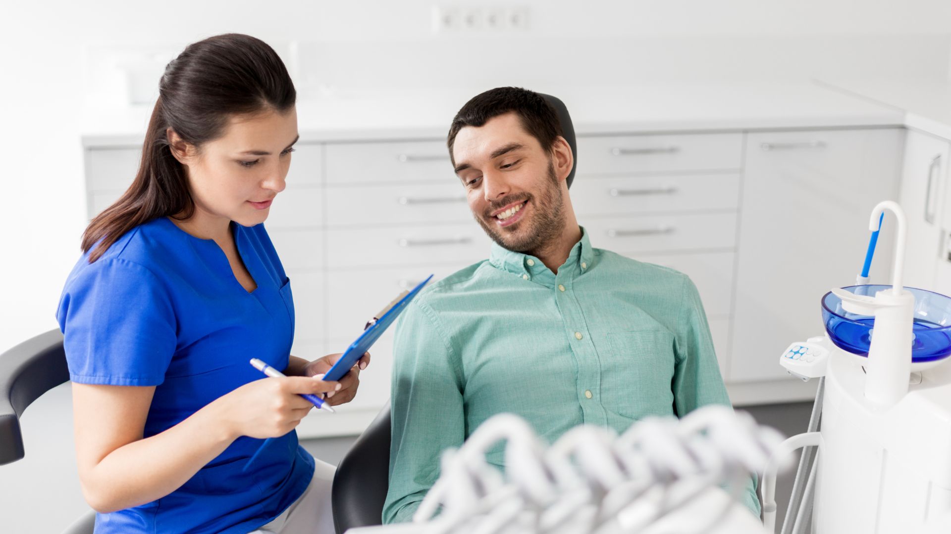 Dentist consulting patient in dental office.