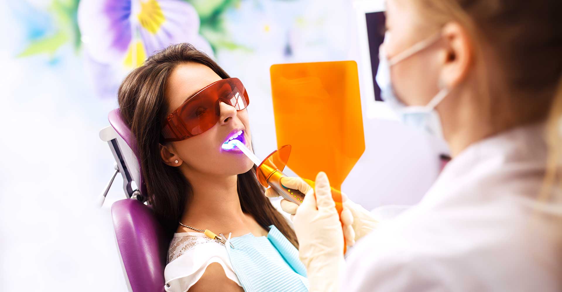 Patient receiving dental treatment with protective eyewear.