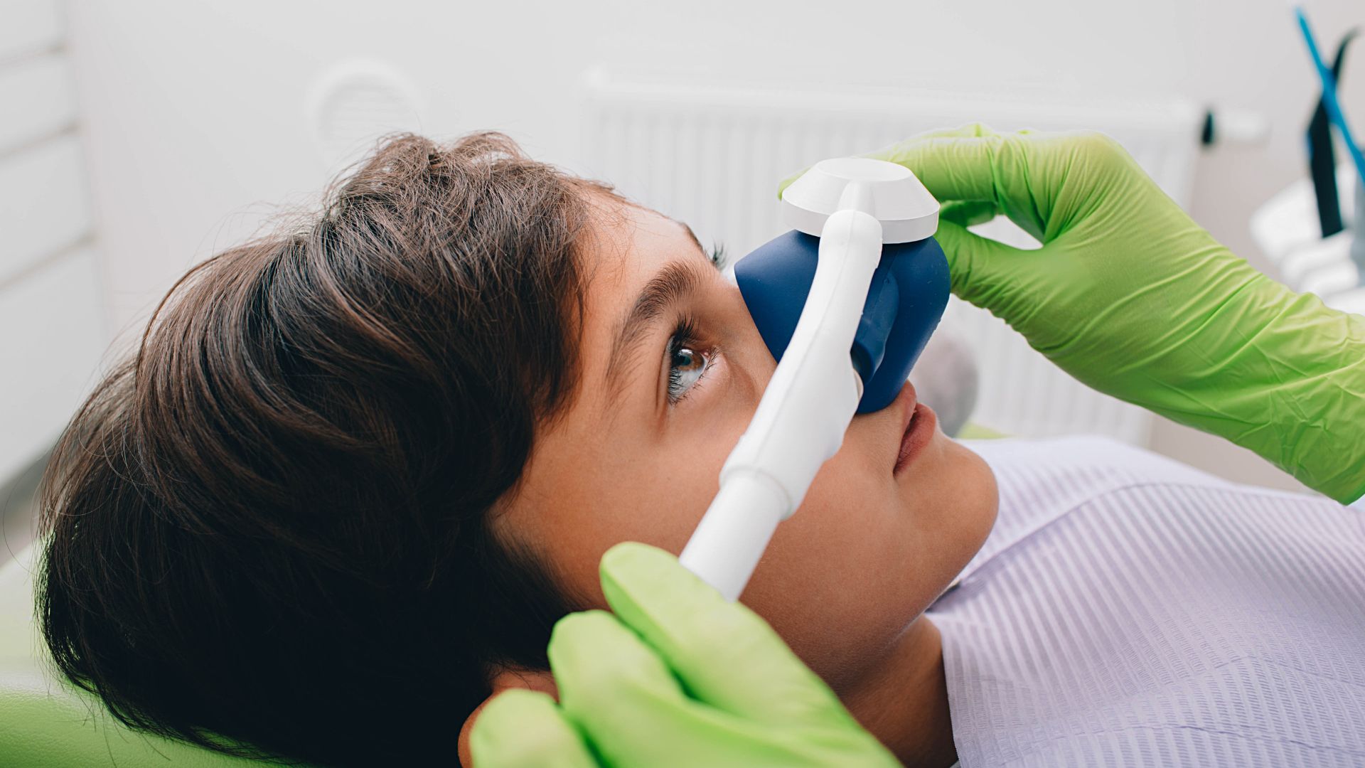 Child receiving dental sedation with nasal mask.