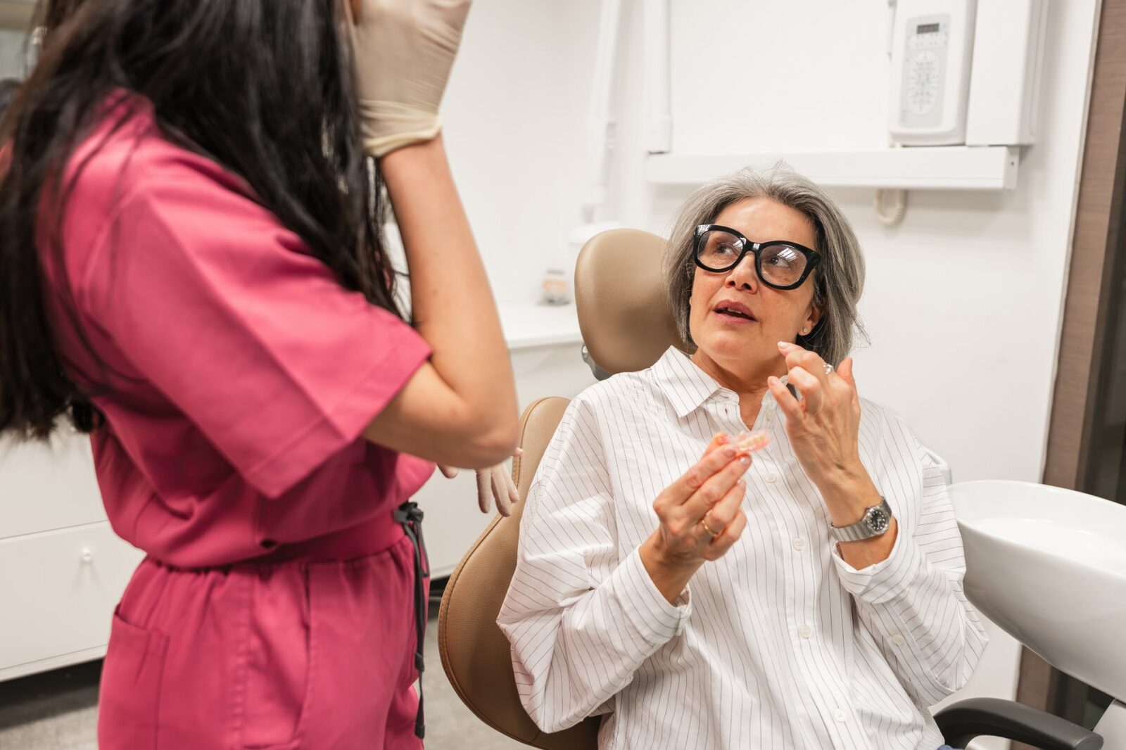 Adult patient asking questions about clear aligners during a dental consultation