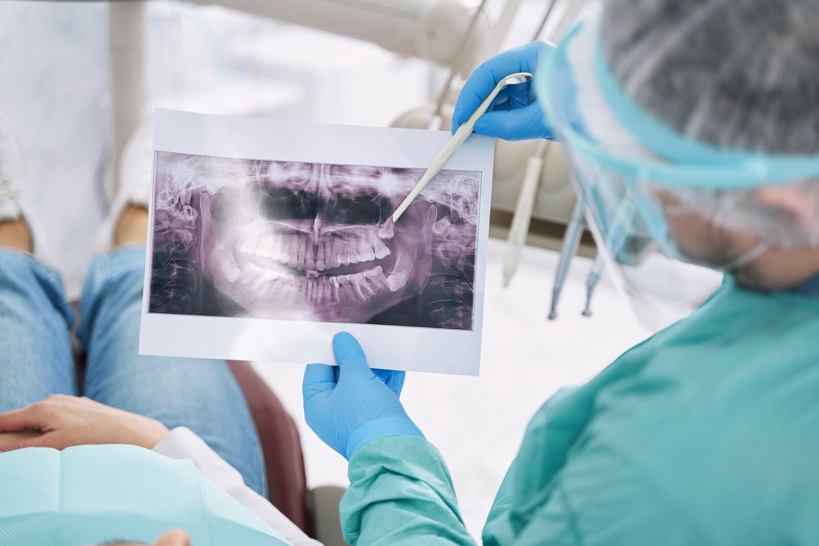 Dentist reviewing a panoramic x-ray to check bone levels around the teeth